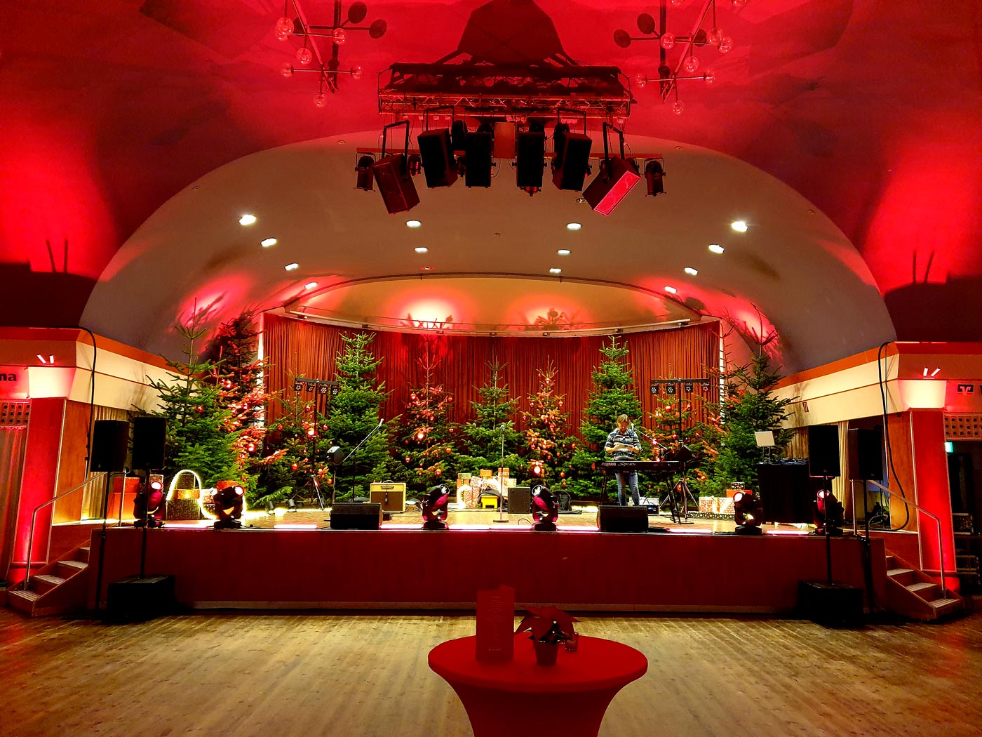 Große Bühne, rotes Bühnenlicht, Weihnachtsbäume auf der Bühne