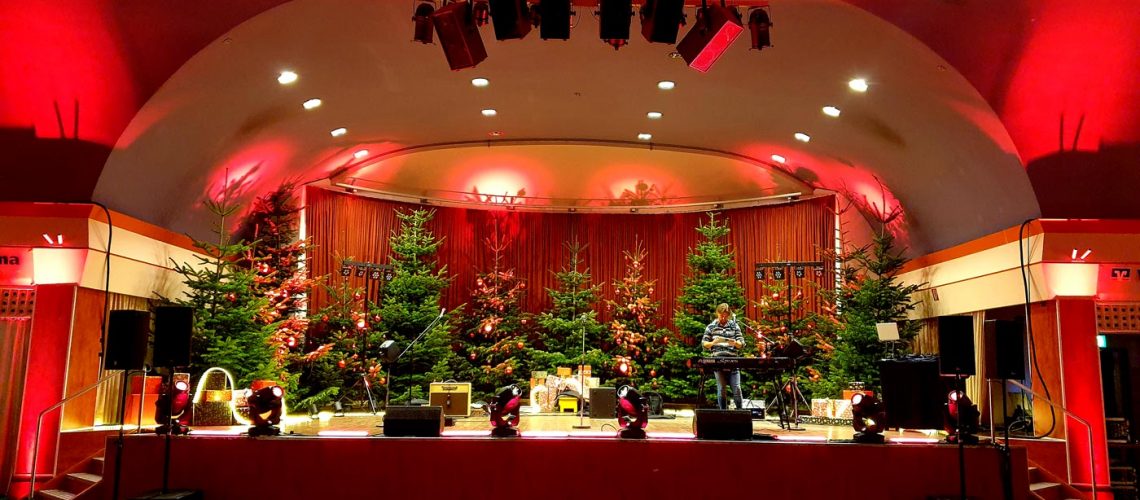 Große Bühne, rotes Bühnenlicht, Weihnachtsbäume auf der Bühne